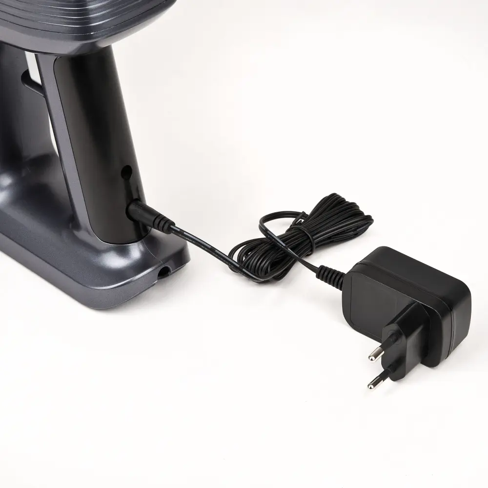 Close-up of the Girmi AP91 cordless vacuum cleaner charging base, cable and two-pin adapter on a white background.