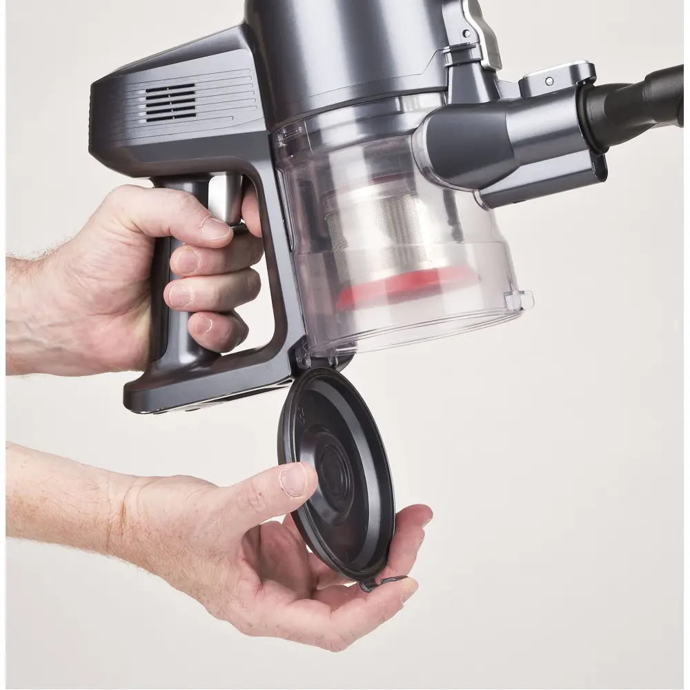 Hand holding the open dust container of the Girmi 22.2V Cordless Vacuum Cleaner AP91, showing its clear bin and black filter